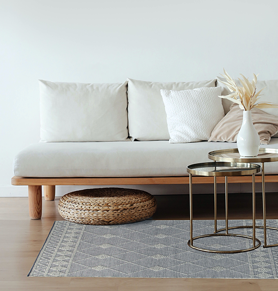 Obraz pokazujący sofę z poduszkami w jasnych kolorach.